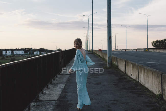Mulher andando na ponte sorrindo — Fotografia de Stock