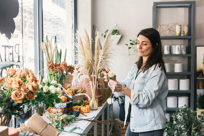 Красивый молодой флорист заботится о цветочных горшках в своем магазине — стоковое фото