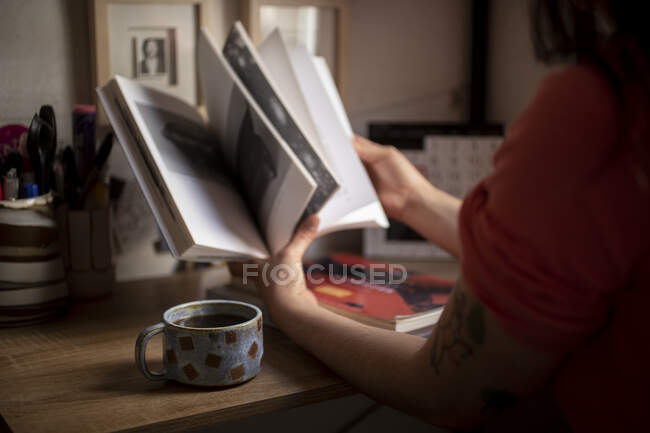 Jovem estudando com uma xícara de café — Fotografia de Stock