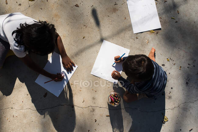 Enfants dessinant sur papier à l'extérieur d'en haut — Photo de stock