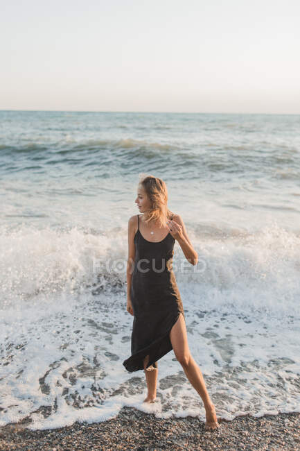 Зрелая женщина позирует на пляже