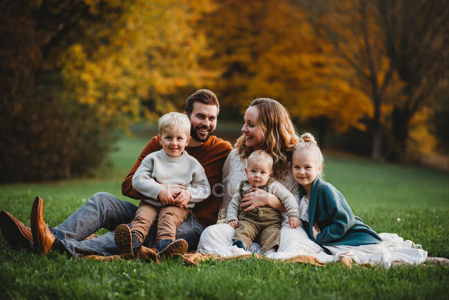 Bela família em um parque sorrindo em um dia de outono — Fotografia de Stock
