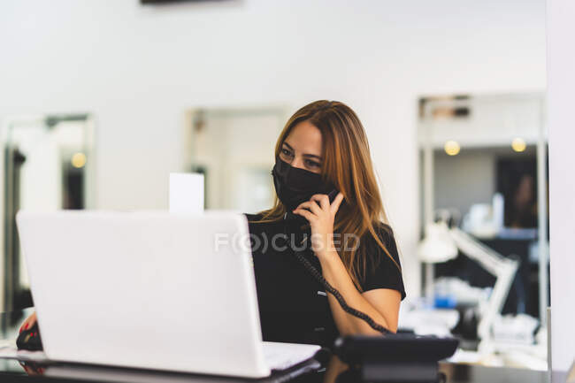 Donna intraprendente che lavora con il suo computer dalla sua attività — Foto stock