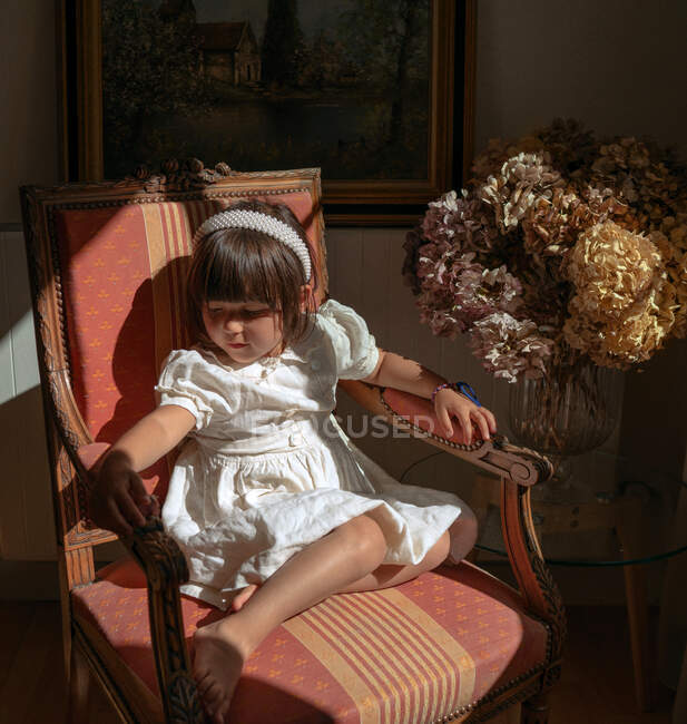 Портрет девушки, сидящей на стуле — стоковое фото