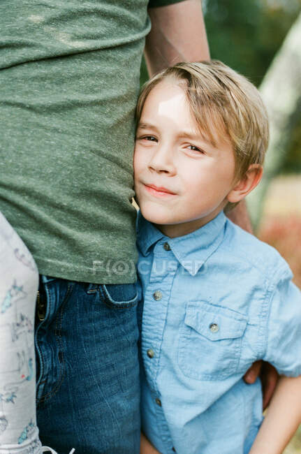 Close up de um menino de cinco anos de idade em seus braços pais — Fotografia de Stock