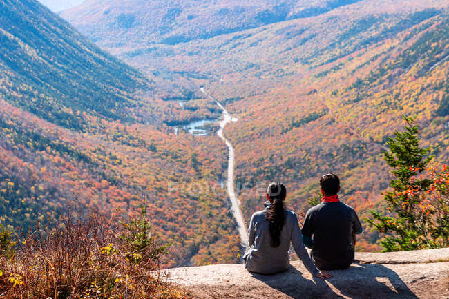 Подорожуюча пара сидить на гірському виступі, дивлячись через долину в Нью - Йорку.. — стокове фото