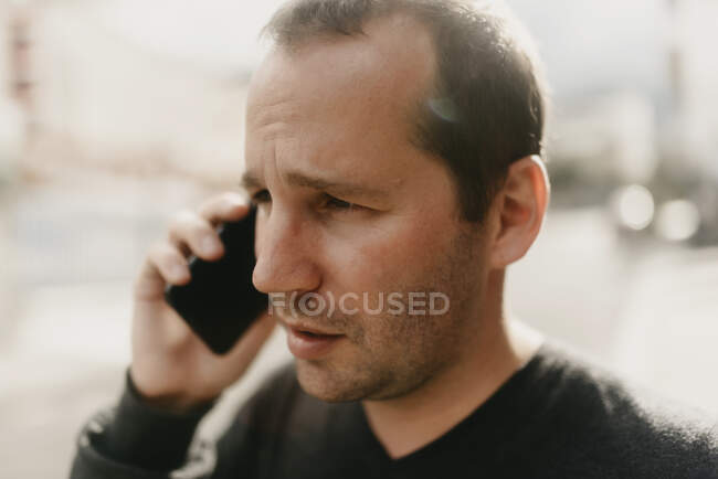 Un hombre hablando por teléfono en la calle - foto de stock