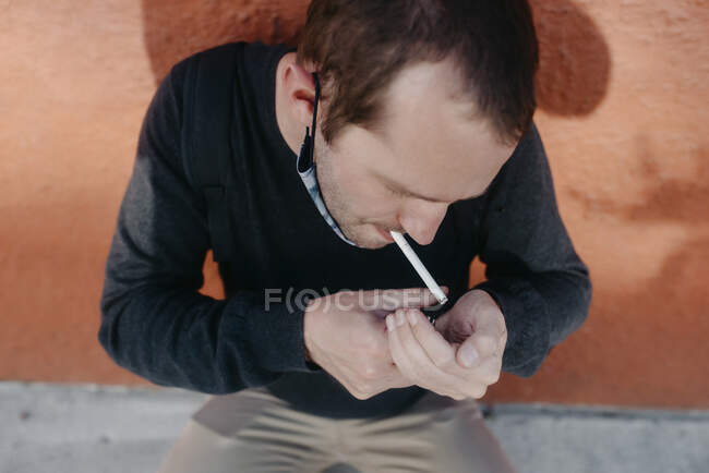 Man lighting a cigarette in the street — Stock Photo