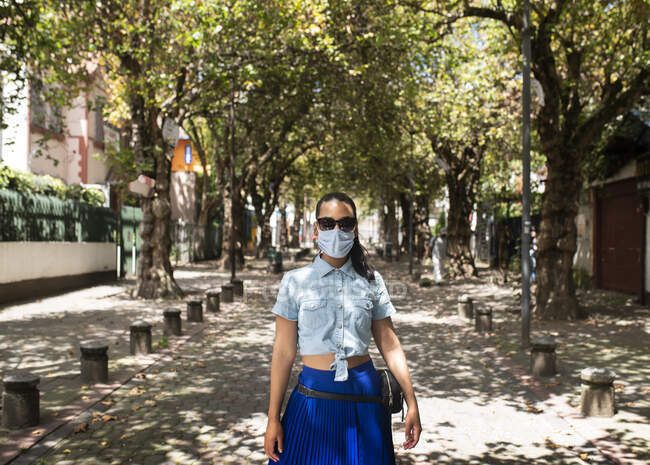 Доросла жінка ходить на вулиці, використовуючи прикриття для рота — стокове фото