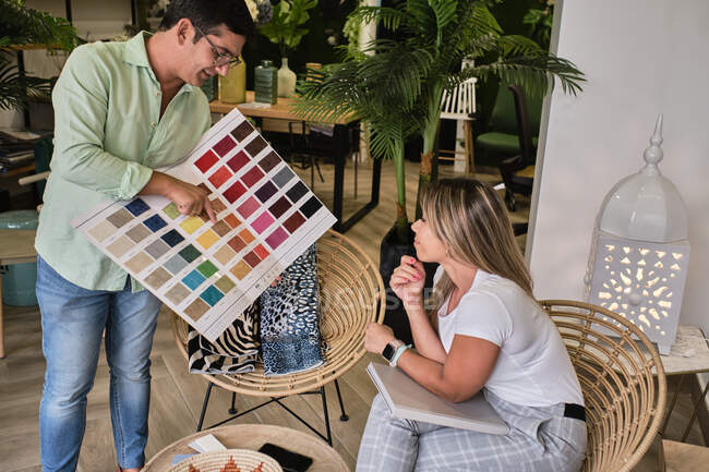 Fabric salesman shows the color chart to his customer — Stock Photo