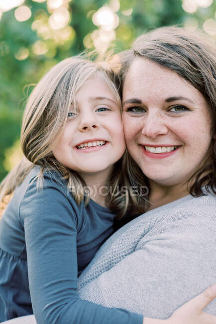 Eine Mutter und ihre Tochter umarmen sich innig und lächeln — Stockfoto