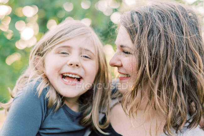 Uma jovem mãe e sua filha rindo juntas — Fotografia de Stock