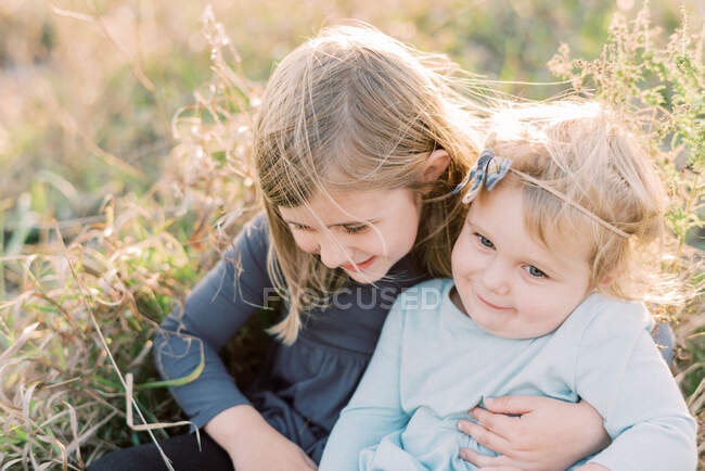Two sisters smiling together on a windy day outside — Stock Photo