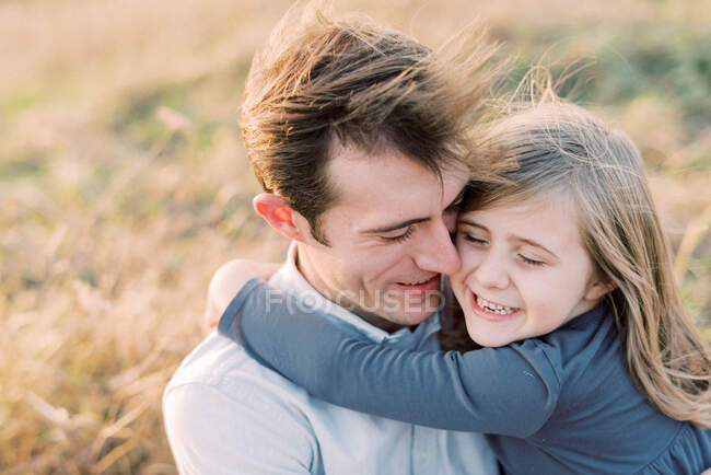 Счастливая и любящая пятилетняя девочка, держащаяся за своего отца — стоковое фото
