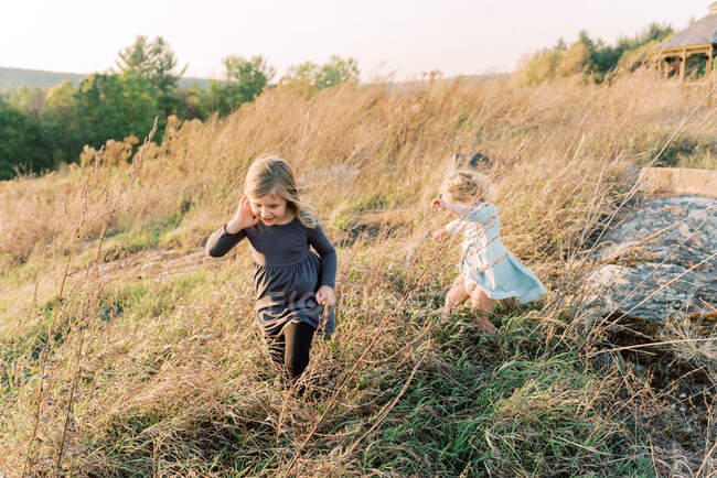 Портрет впевнених і щасливих дівчат під час заходу сонця в полі — стокове фото