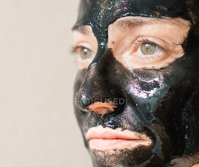 Girl with active charcoal mask relaxed in a spa — Stock Photo