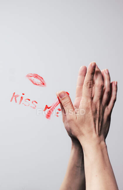 Effacer à la main la phrase baiser moi faite avec du rouge à lèvres sur un miroir — Photo de stock