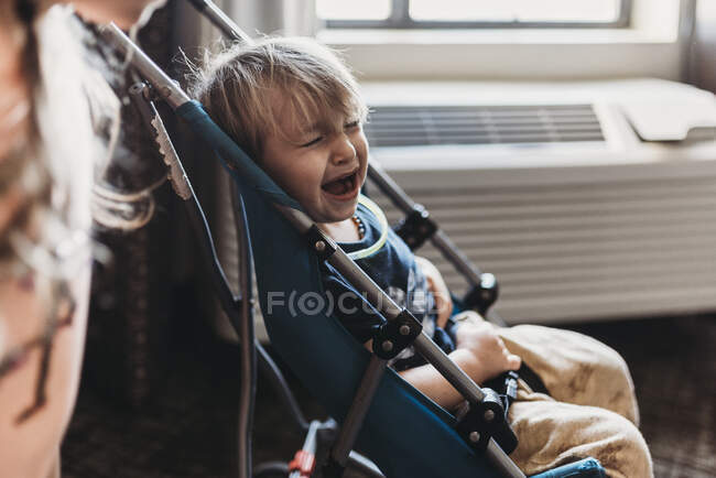 Young toddler boy crying in his stroller in hotel room in Palm Springs — Stock Photo
