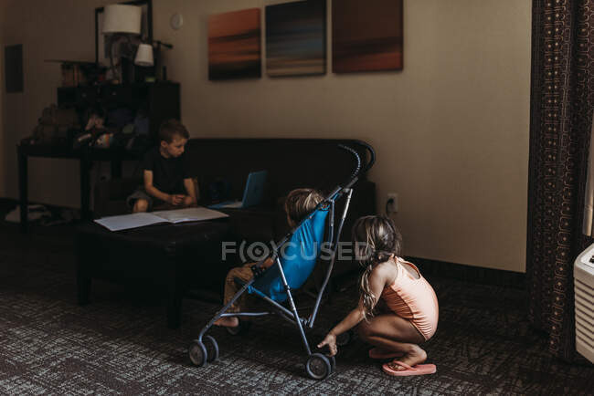 Jovens irmãos brincando em carrinho no quarto de hotel em Palm Springs — Fotografia de Stock