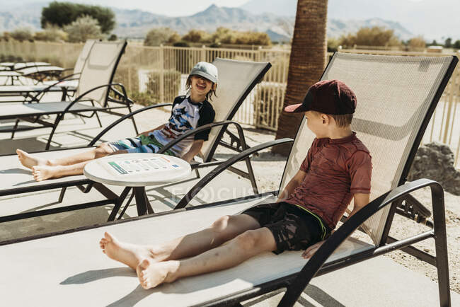 Close up vista de jovens irmãos em cadeiras de piscina rindo juntos — Fotografia de Stock