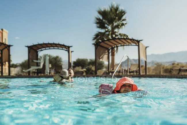 Молода дівчина дошкільного віку плаває в басейні під час відпустки в Палм - Спрінгс. — стокове фото