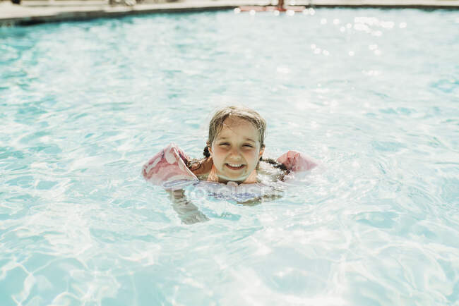 Молода дівчина дошкільного віку плаває в басейні під час відпустки в Палм - Спрінгс. — стокове фото