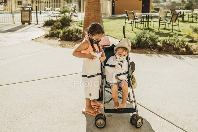 Bambini piccoli con passeggino che lasciano la piscina con maschere in vacanza — Foto stock