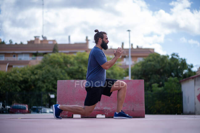 Чоловік тренує ноги сильними легенями в парку на відкритому повітрі — стокове фото