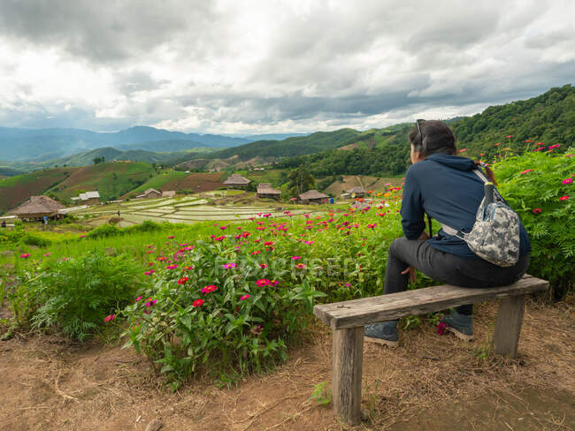 Une femme assise et regardant les terrasses de riz. — Photo de stock
