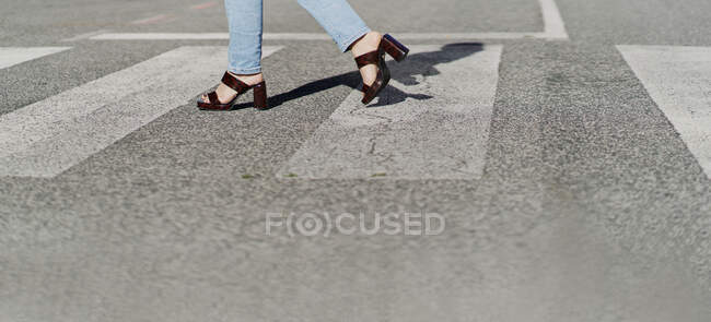 Frau läuft mit Stöckelschuhen auf Zebrastreifen — Stockfoto