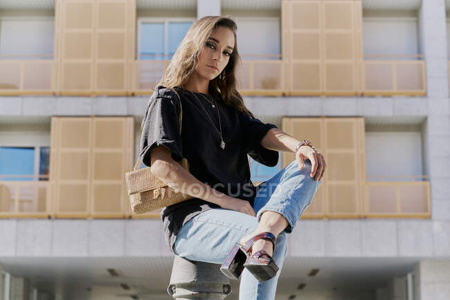 Porträt einer jungen Frau mit blonden Locken und brauner Handtasche — Stockfoto