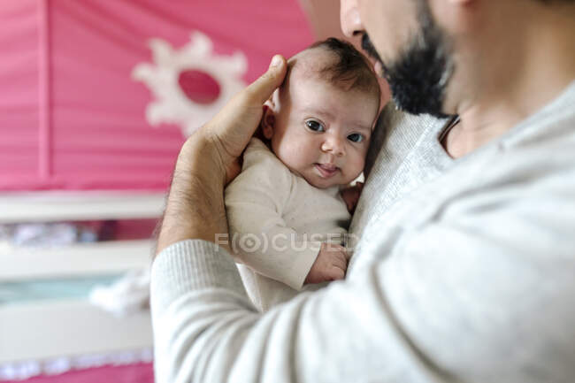 Zarter Vater mit Bart kuschelt Säugling mit großen braunen Augen — Stockfoto