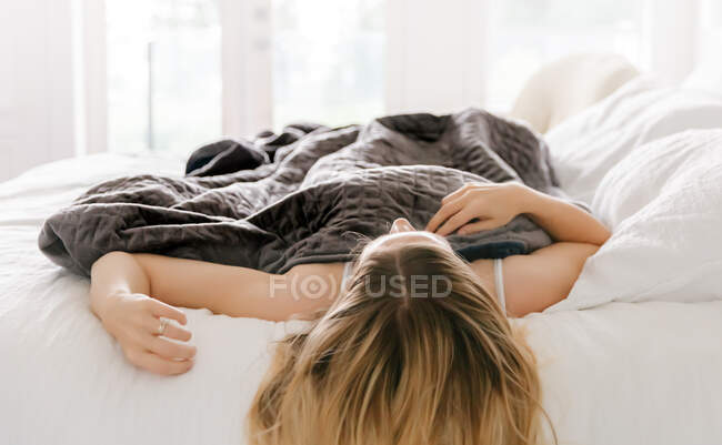 Молода жінка спить у ліжку — стокове фото