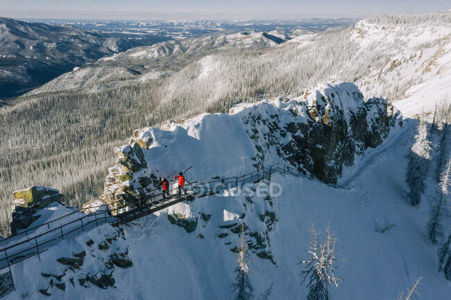Skiers hiking walkway along mountain peaks photographed from drone — Stock Photo