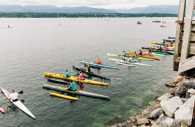 Kayak line up bright colours on the ocean, race — Stock Photo
