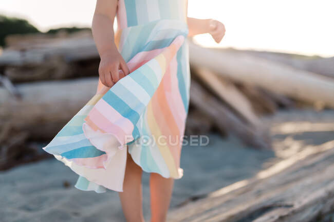 Мягкое радужное платье на пляже на закате — стоковое фото