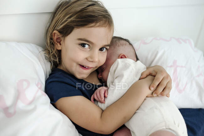 Linda niña con su hermana pequeña - foto de stock