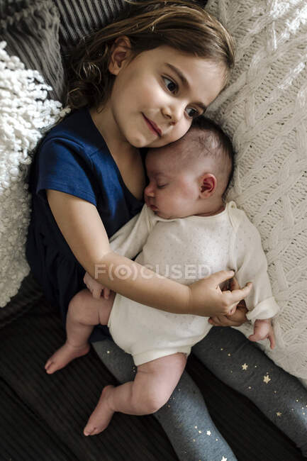 Linda niña con su hermana pequeña - foto de stock