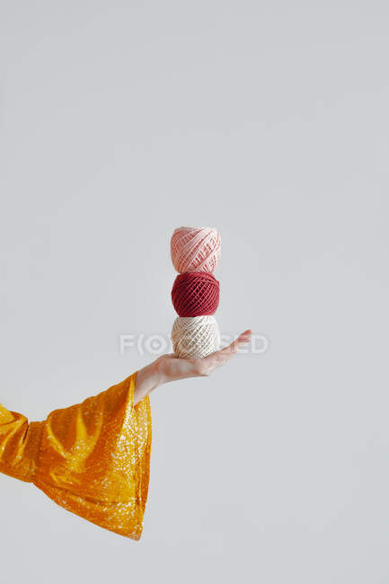 Rollos de cuerdas de algodón en mano de mujer. Tejer, ganchillo, concepto de hobby hecho a mano - foto de stock