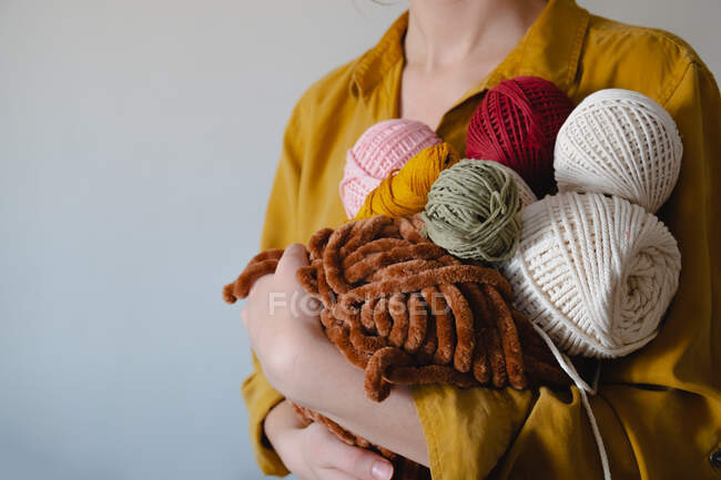 Rolos de cordas de algodão na mão da mulher. Tricô, crochê, conceito de passatempo artesanal — Fotografia de Stock