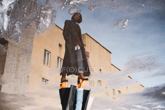 Reflection of a woman posing in front of generic building, full length portrait — Stock Photo