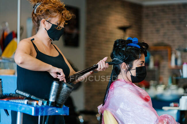 Mujer en la peluquería con máscara, salón de belleza - foto de stock