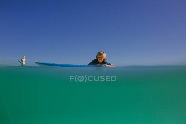 Siblings paddleboard in turquoise waters of Hawaii — Stock Photo