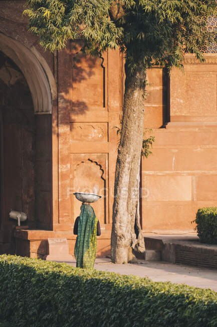 Woman dressed in green sari walking by the Agra Fort, Agra — Stock Photo