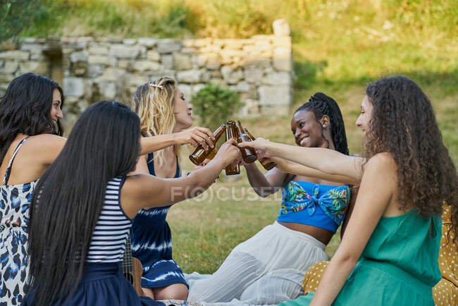 Grupo de mulheres amigas bebendo cerveja em um parque no dia de verão — Fotografia de Stock