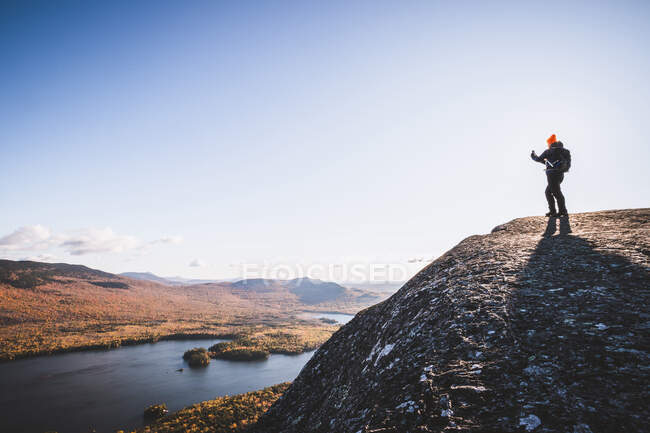 Woman hiker takes cell phone picture on mountaintop in Maine in fall — Stock Photo