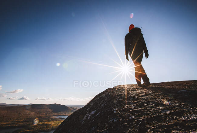 Wanderer erreicht felsigen Gipfel des Berges an klaren, sonnigen Herbsttagen — Stockfoto