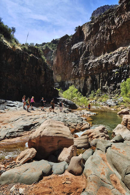 Hikers making their way past a pool on Cibeque Creek, in Arizona — Stock Photo