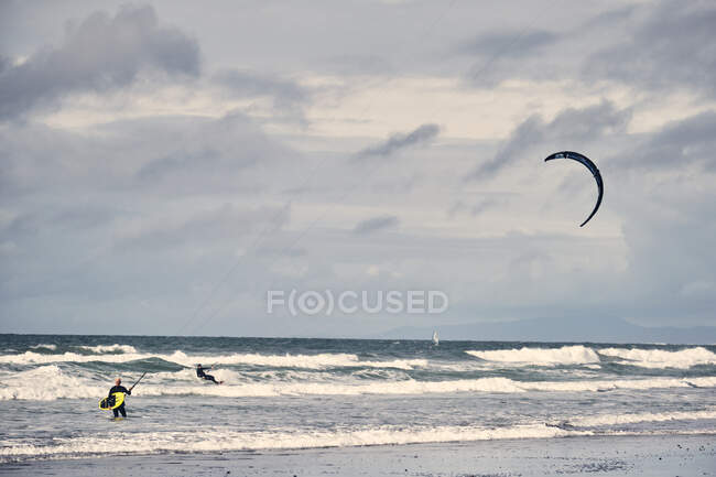 Kite surfers make their way in out of the waves on a California Beach — Stock Photo