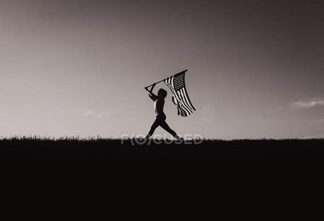 Mulher carregando bandeira americana — Fotografia de Stock